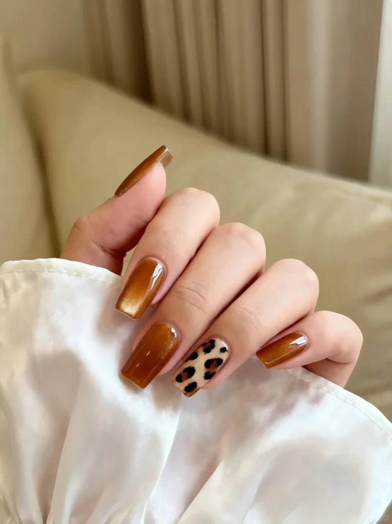 Shimmering bronze nails featuring stylish leopard art accent.