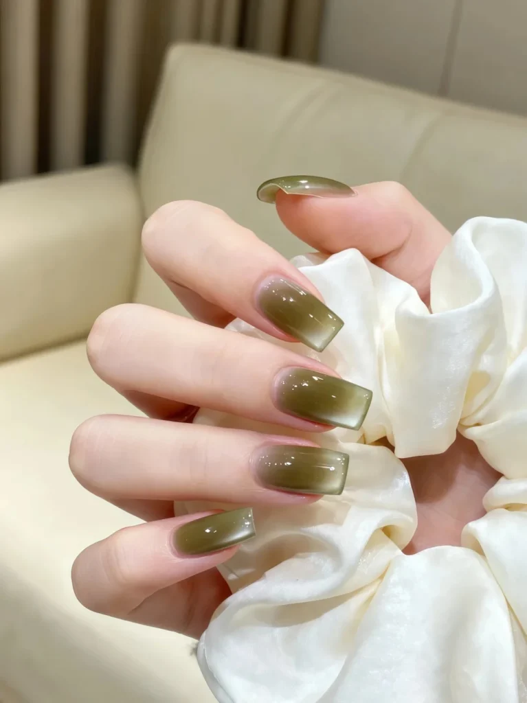 Stylish olive green manicure with glossy smooth surface.