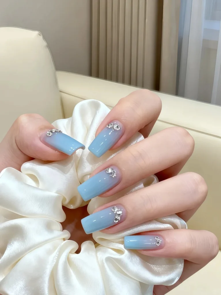 Glossy blue manicure with tiny white stars and a soft shimmer.