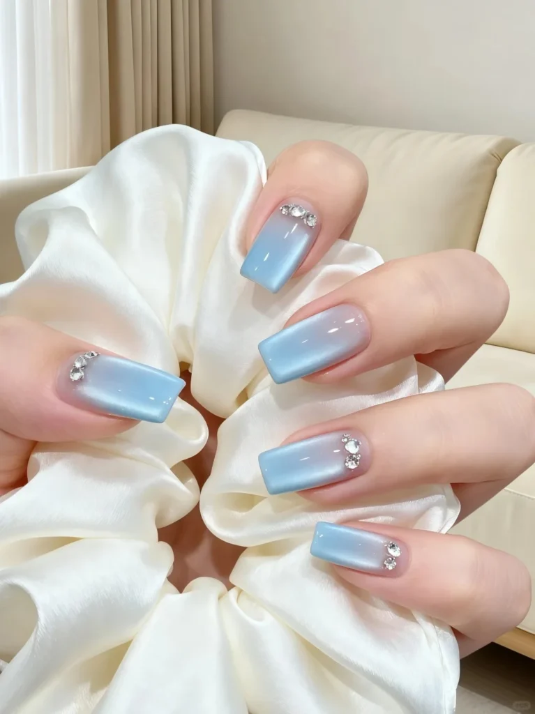 Beautiful sky blue nails with shiny chrome effect and smooth finish.
