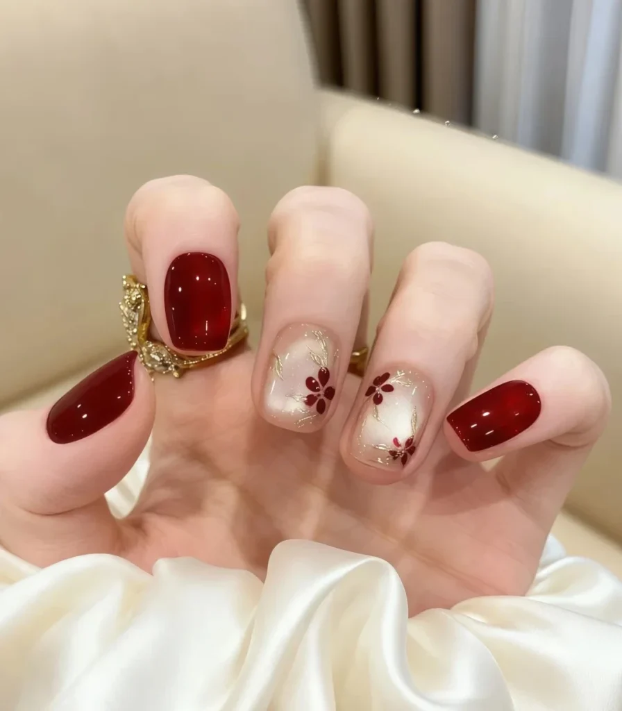 Sparkly maroon nails featuring delicate star-style glitter.