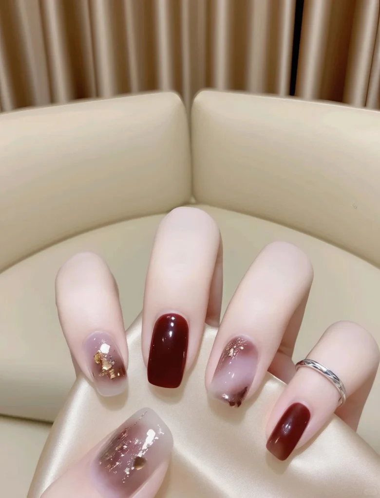 Shiny red nails decorated with glitter and rhinestones.